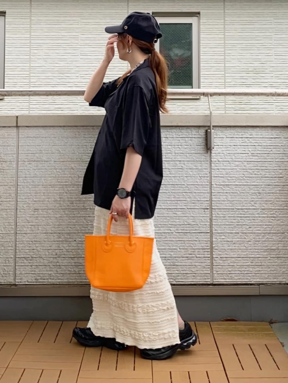 ブラック系のシャツ/ブラウス、ホワイト系のスカート、オレンジ系のトートバッグを着用したレディースの夏コーディネートの2枚目の写真