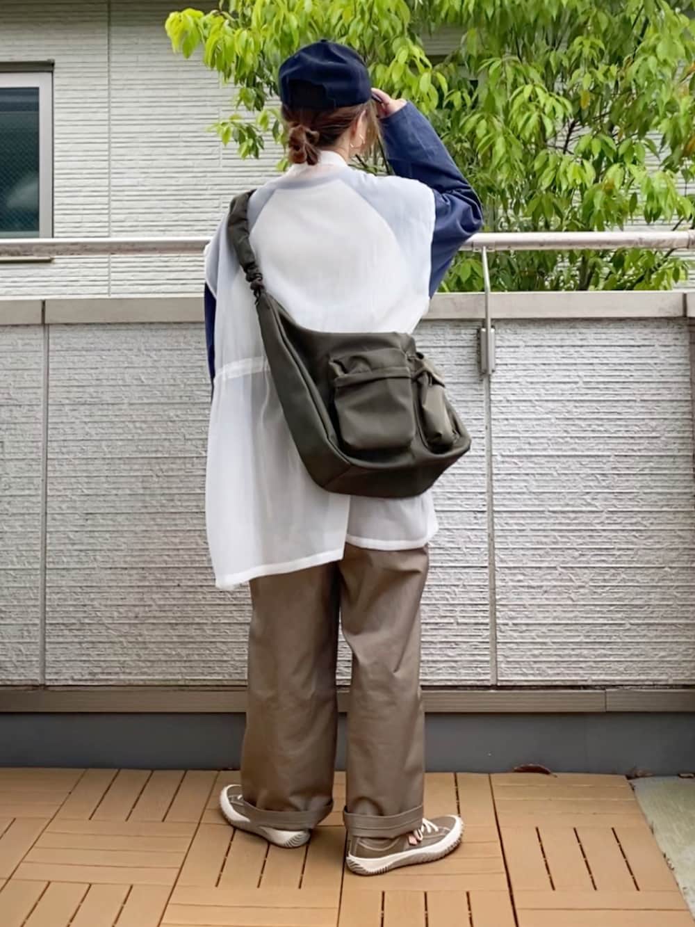 ホワイト系のTシャツ/カットソー、ホワイト系のベスト、ベージュ系のチノパンツを着用したレディースの春コーディネートの4枚目の写真