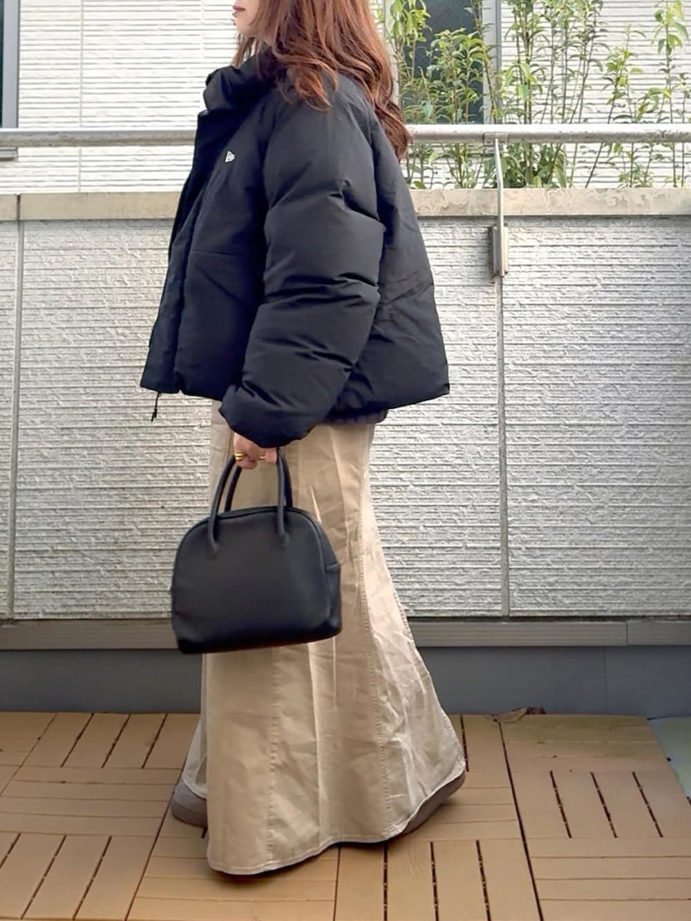 ブラック系のその他アウター、グレー系のニット/セーター、ベージュ系のスカートを着用したレディースの冬コーディネートの3枚目の写真