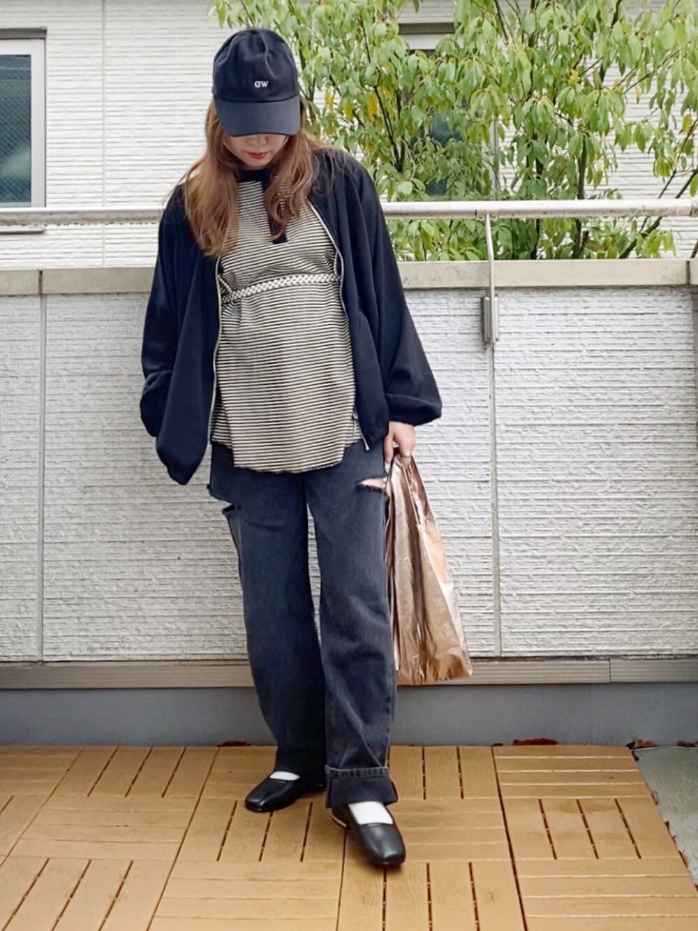 ホワイト系のTシャツ/カットソー、ブラック系のブルゾン、ブラック系のデニムパンツを着用したレディースの春コーディネートの5枚目の写真