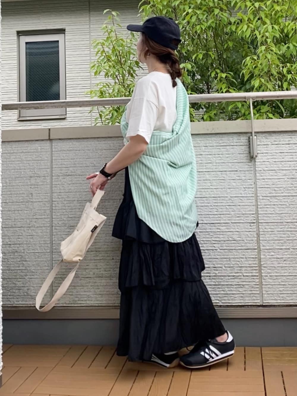 ホワイト系のTシャツ/カットソー、グリーン系のシャツ/ブラウス、ブラック系のスカートを着用したレディースの夏コーディネートの2枚目の写真