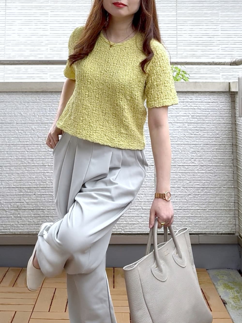 グリーン系のTシャツ/カットソー、グレー系のスラックス、ゴールド系のアナログ腕時計を着用したレディースの夏コーディネートの5枚目の写真