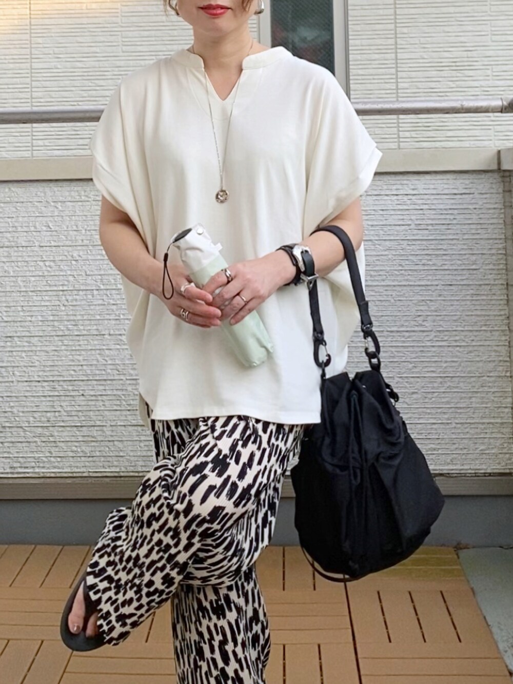 ホワイト系のTシャツ/カットソー、ホワイト系のその他パンツ、ブラック系のショルダーバッグを着用したレディースの夏コーディネートの5枚目の写真