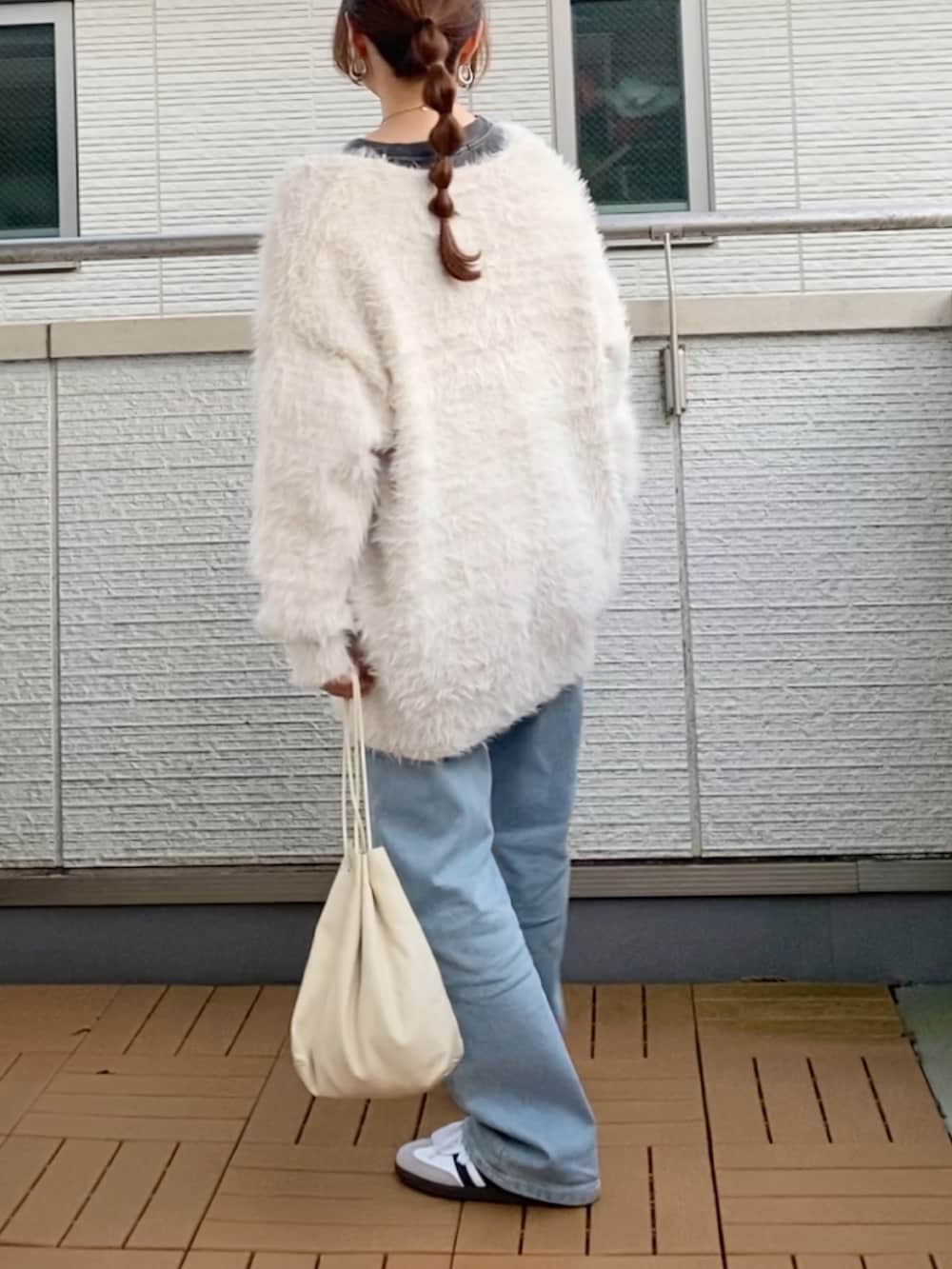 ホワイト系のカーディガン/ボレロ、ブラック系のTシャツ/カットソー、ブルー系のデニムパンツを着用したレディースの秋コーディネートの3枚目の写真