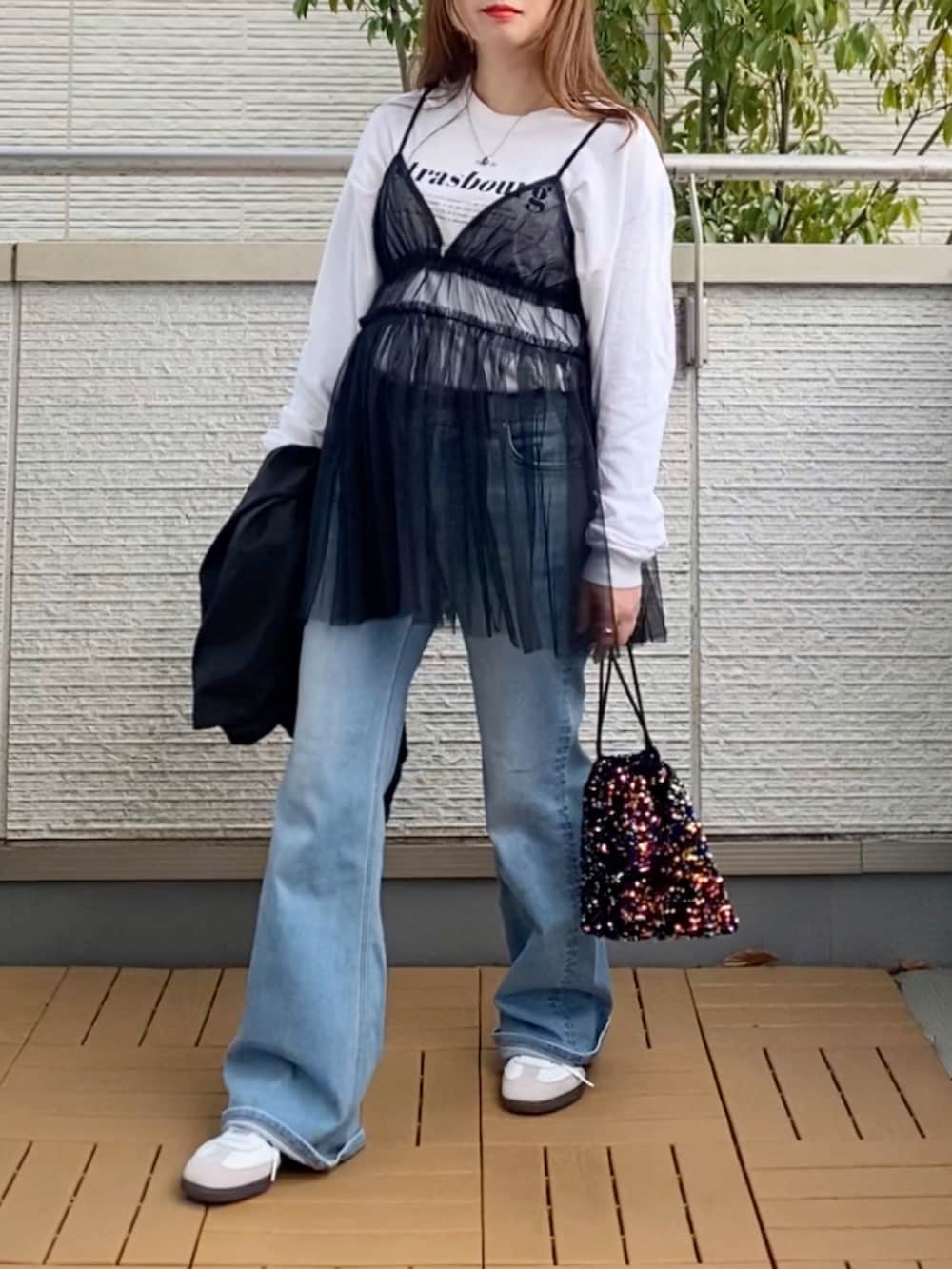 ブラック系のキャミソール、ホワイト系のTシャツ/カットソー、ブラック系のナイロンジャケットを着用したレディースの春コーディネートの3枚目の写真