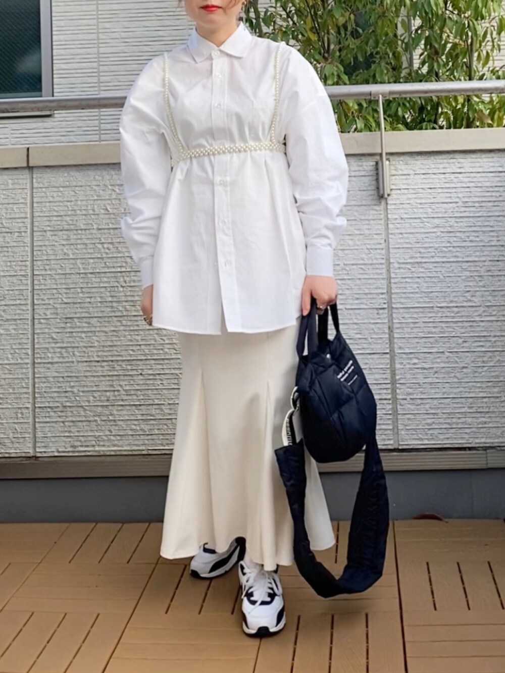 ホワイト系のシャツ/ブラウス、ホワイト系のスカート、ブラック系のショルダーバッグを着用したレディースの春コーディネートの2枚目の写真