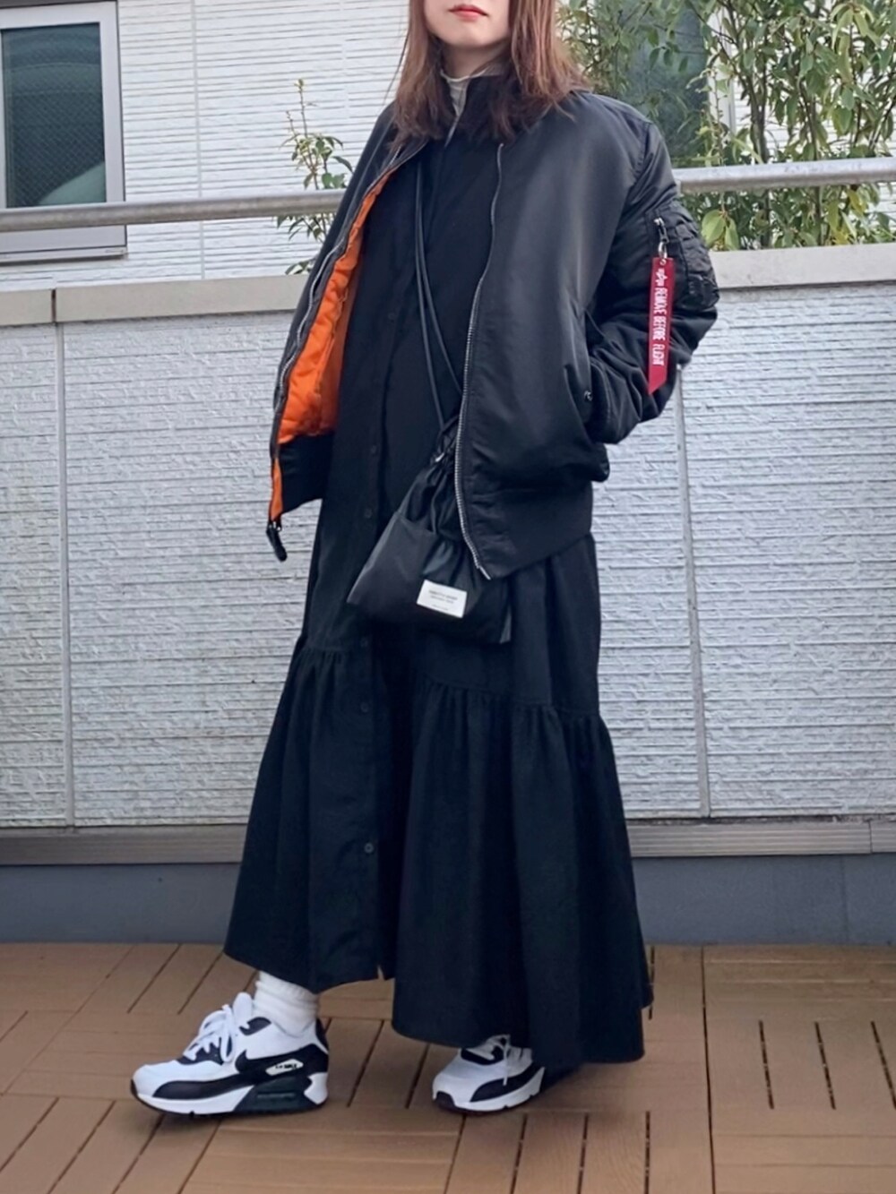 ブラック系のMA-1、ブラック系のワンピース、ブラック系のショルダーバッグを着用したレディースの冬コーディネートの2枚目の写真