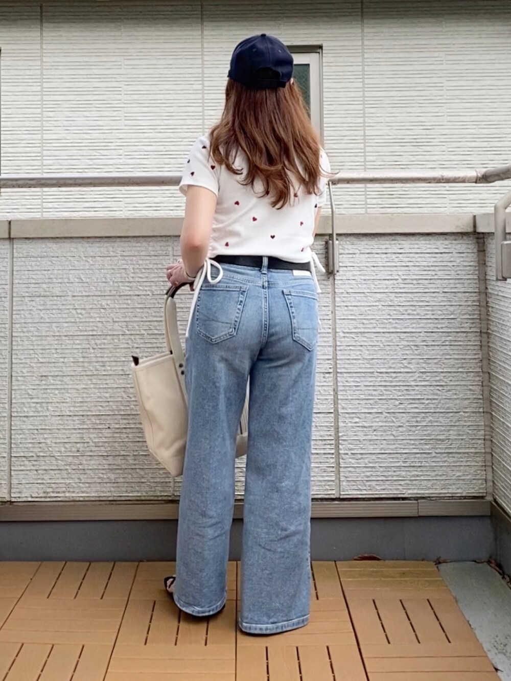 ホワイト系のTシャツ/カットソー、ブルー系のデニムパンツ、ホワイト系のトートバッグを着用したレディースの夏コーディネートの3枚目の写真