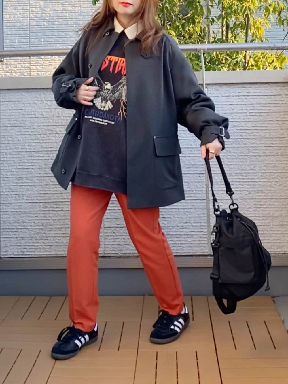 グレー系のブルゾン、グレー系のスウェット、オレンジ系のその他パンツを着用したレディースの冬コーディネートの2枚目の写真