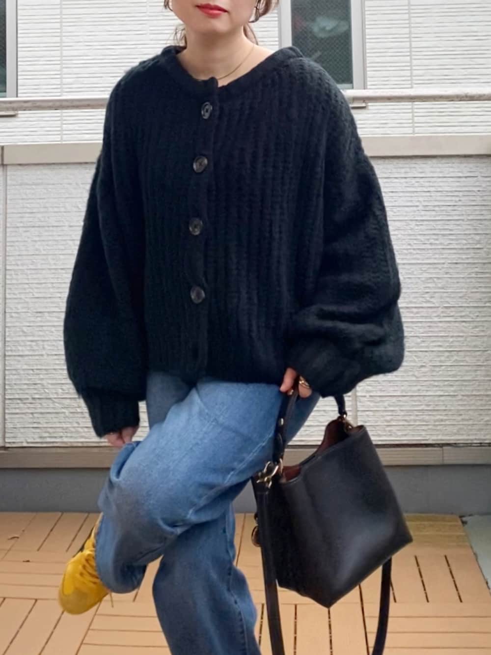 ブラック系のカーディガン/ボレロ、ブルー系のデニムパンツ、ブラック系のショルダーバッグを着用したレディースの秋コーディネートの5枚目の写真