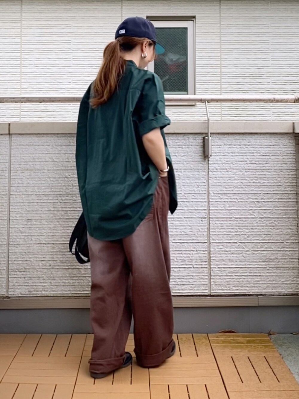 グリーン系のシャツ/ブラウス、ブラウン系のデニムパンツ、ブラック系のショルダーバッグを着用したレディースの夏コーディネートの2枚目の写真