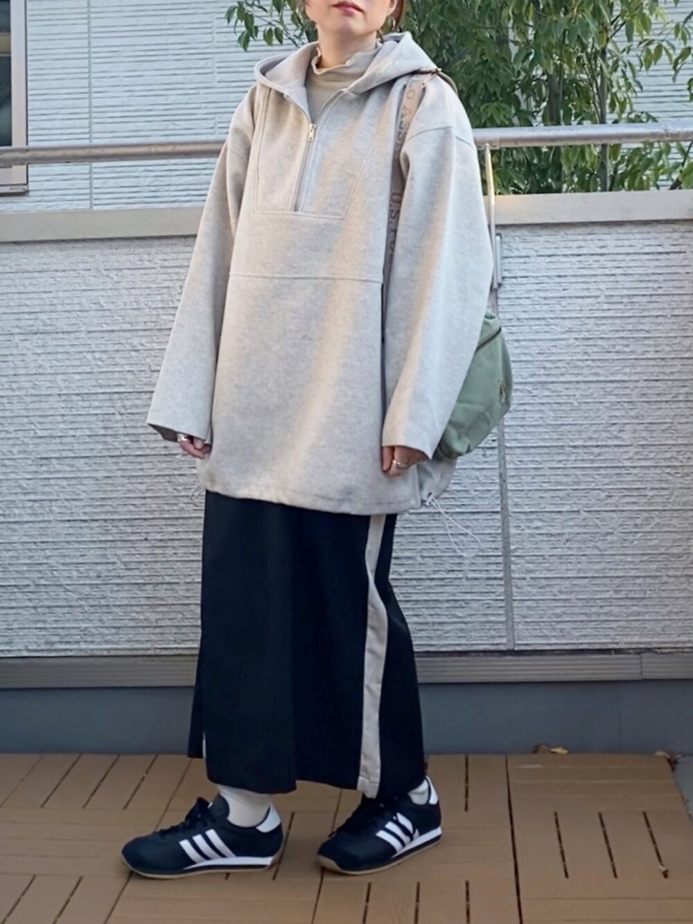 ホワイト系のパーカー、ホワイト系のTシャツ/カットソー、ブラック系のスカートを着用したレディースの冬コーディネートの5枚目の写真