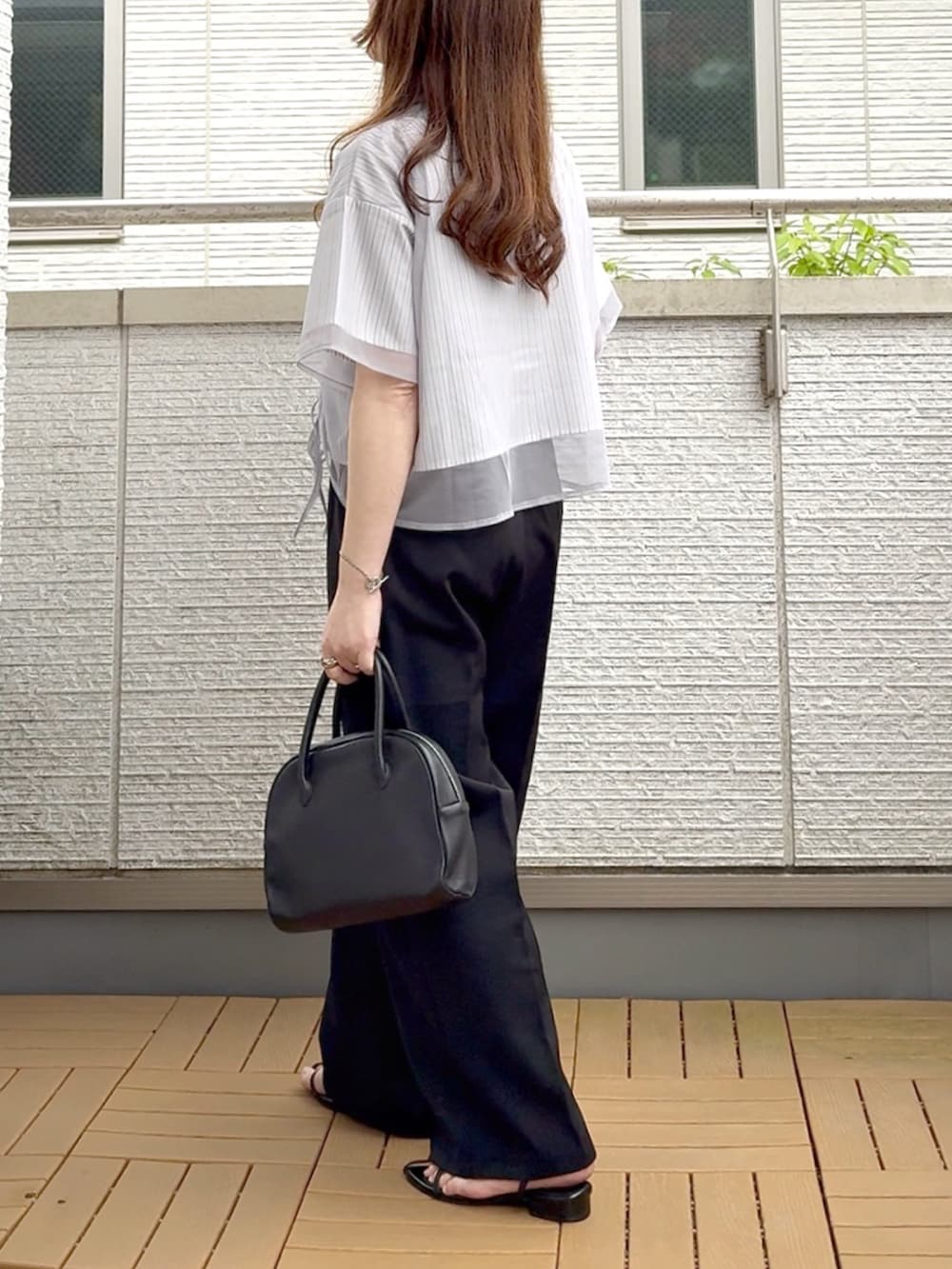 グレー系のシャツ/ブラウス、ブラック系のスラックス、ブラック系のショルダーバッグを着用したレディースの夏コーディネートの4枚目の写真