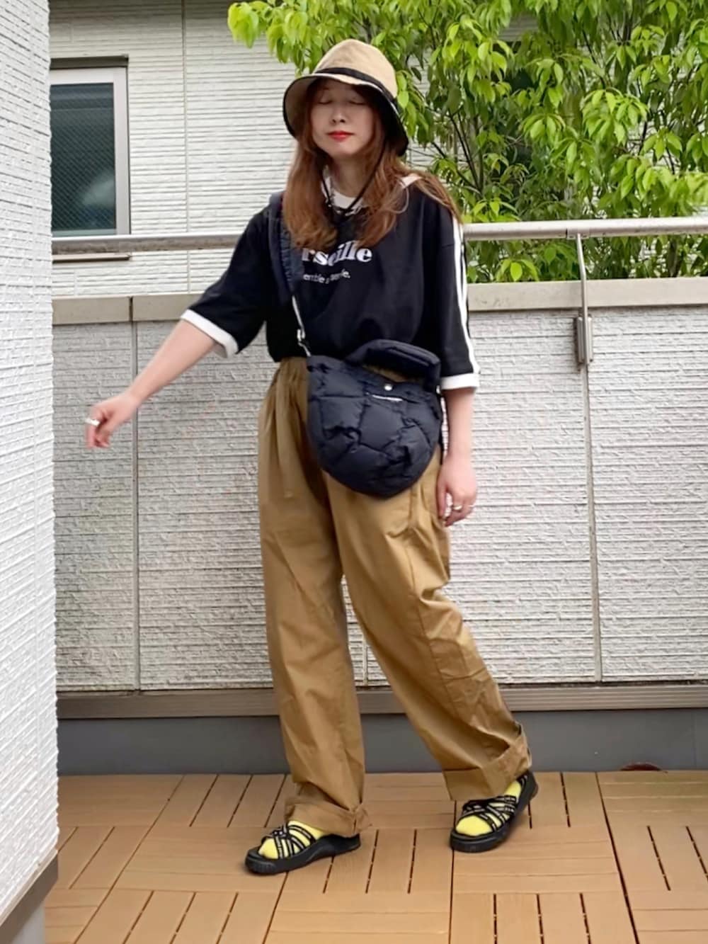 ブラック系のTシャツ/カットソー、ベージュ系のその他パンツ、ブラック系のショルダーバッグを着用したレディースの春コーディネートの2枚目の写真