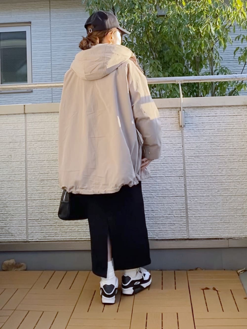 ベージュ系のマウンテンパーカー、ホワイト系のスウェット、ブラック系のスカートを着用したレディースの冬コーディネートの3枚目の写真