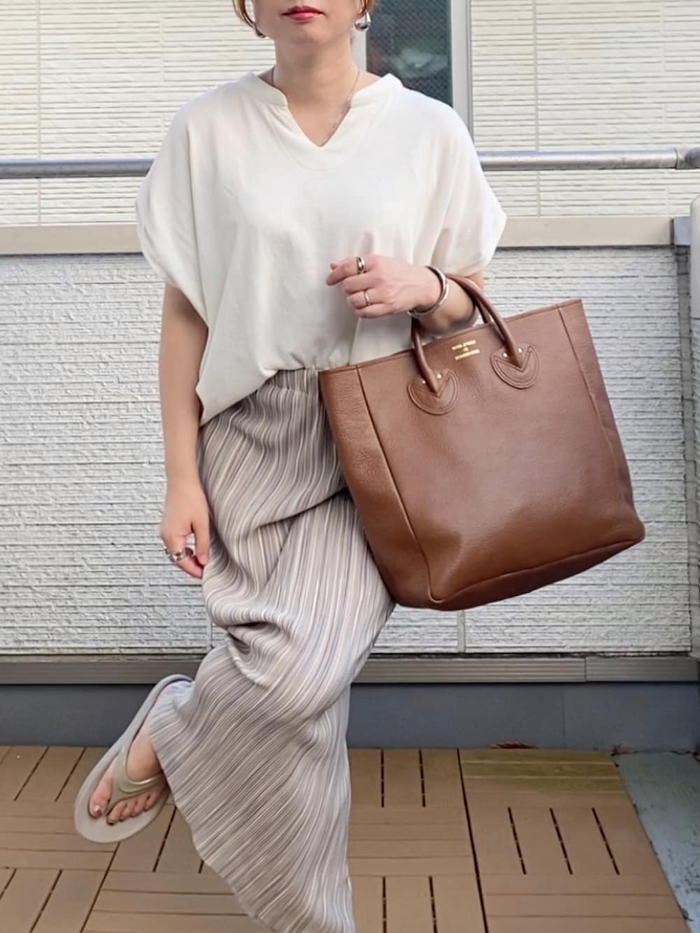 ホワイト系のTシャツ/カットソー、グレー系のスカート、ブラウン系のトートバッグを着用したレディースの夏コーディネートの3枚目の写真