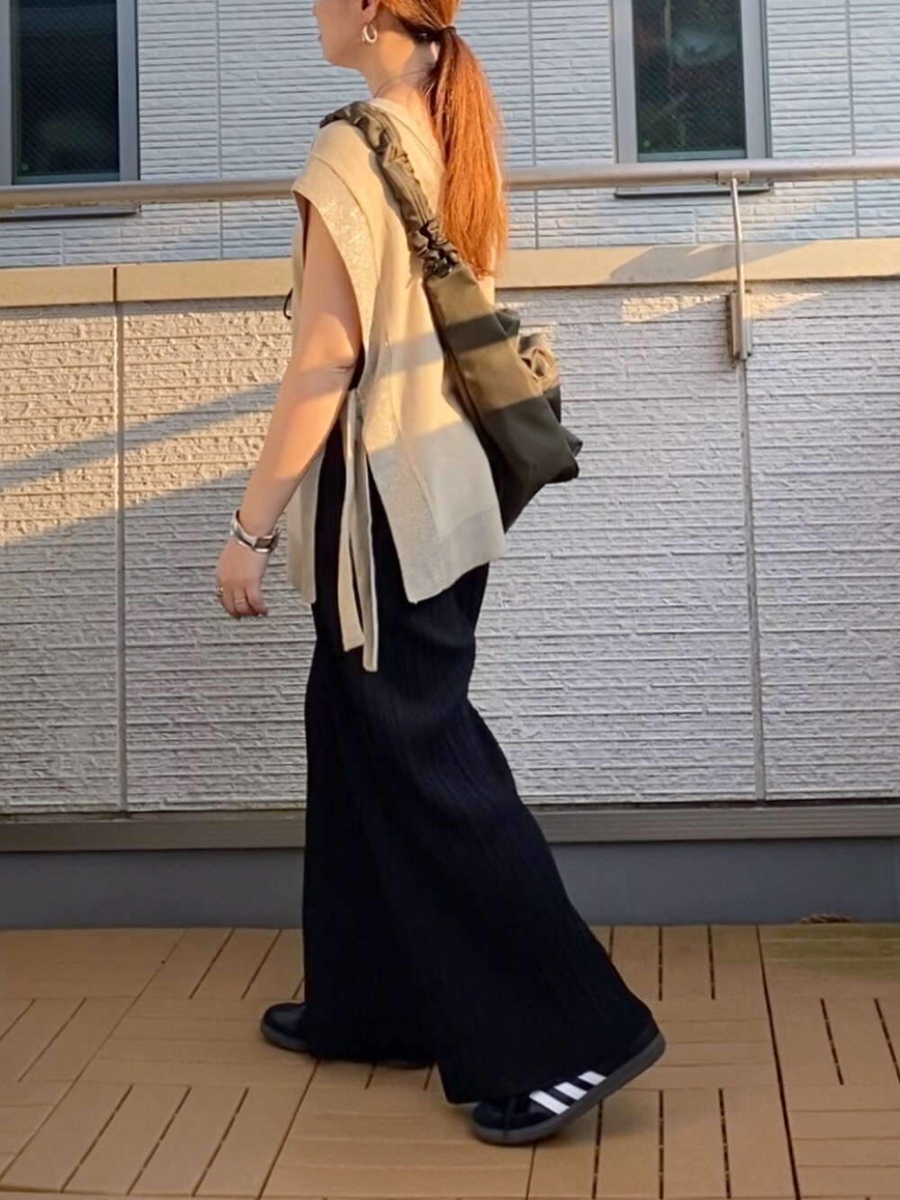 ベージュ系のニット/セーター、ブラック系のその他パンツ、グリーン系のショルダーバッグを着用したレディースの秋コーディネートの3枚目の写真