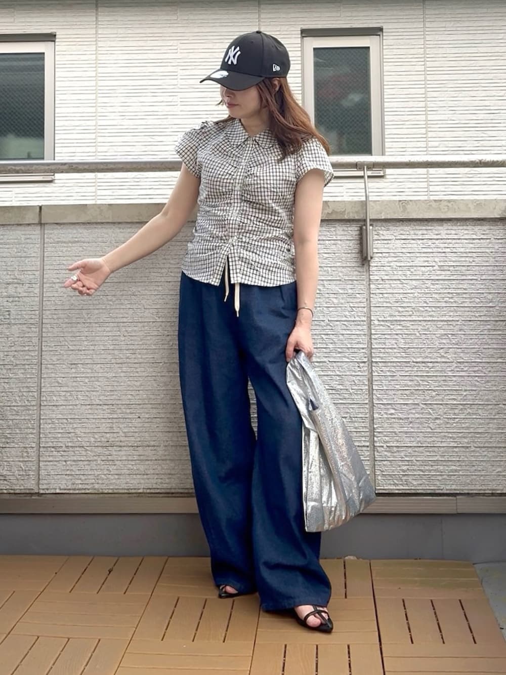 ホワイト系のシャツ/ブラウス、ブルー系のデニムパンツ、ブラック系のキャップを着用したレディースの夏コーディネートの2枚目の写真