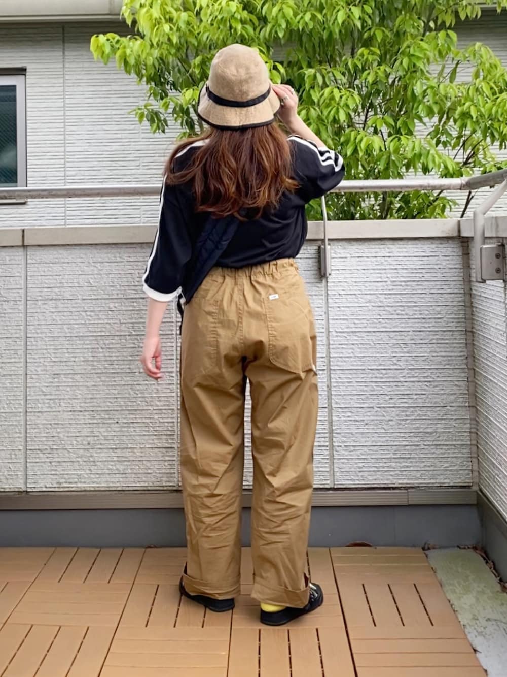 ブラック系のTシャツ/カットソー、ベージュ系のその他パンツ、ブラック系のショルダーバッグを着用したレディースの春コーディネートの3枚目の写真