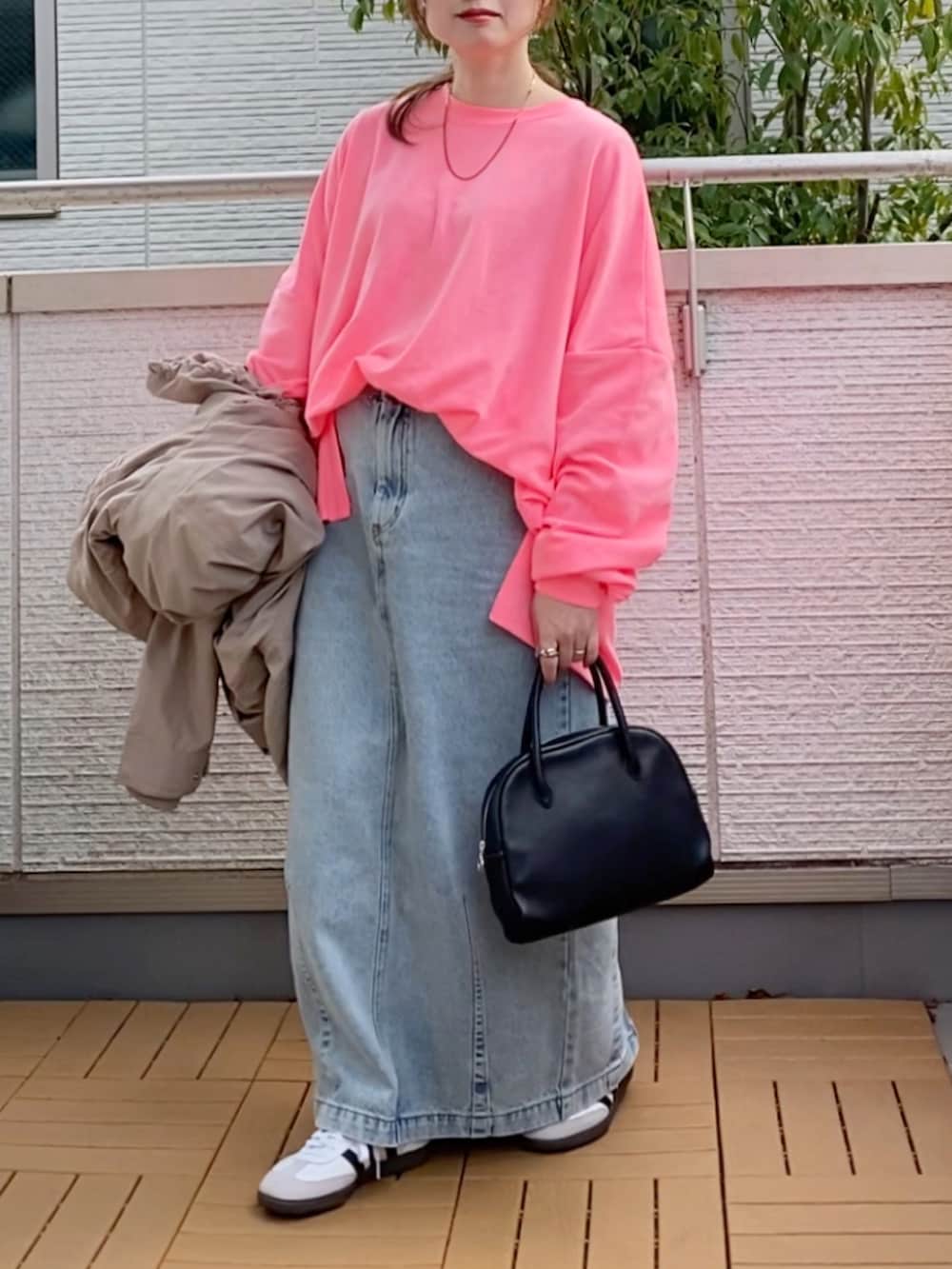ピンク系のTシャツ/カットソー、ベージュ系のマウンテンパーカー、ブルー系のデニムスカートを着用したレディースの冬コーディネートの4枚目の写真