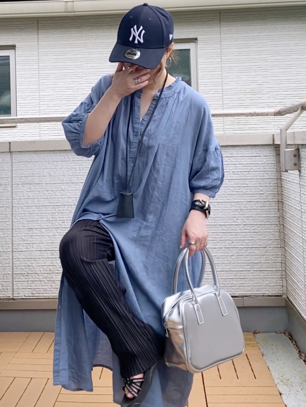 ブルー系のワンピース、ブラック系のその他パンツ、シルバー系のボストンバッグを着用したレディースの夏コーディネートの4枚目の写真