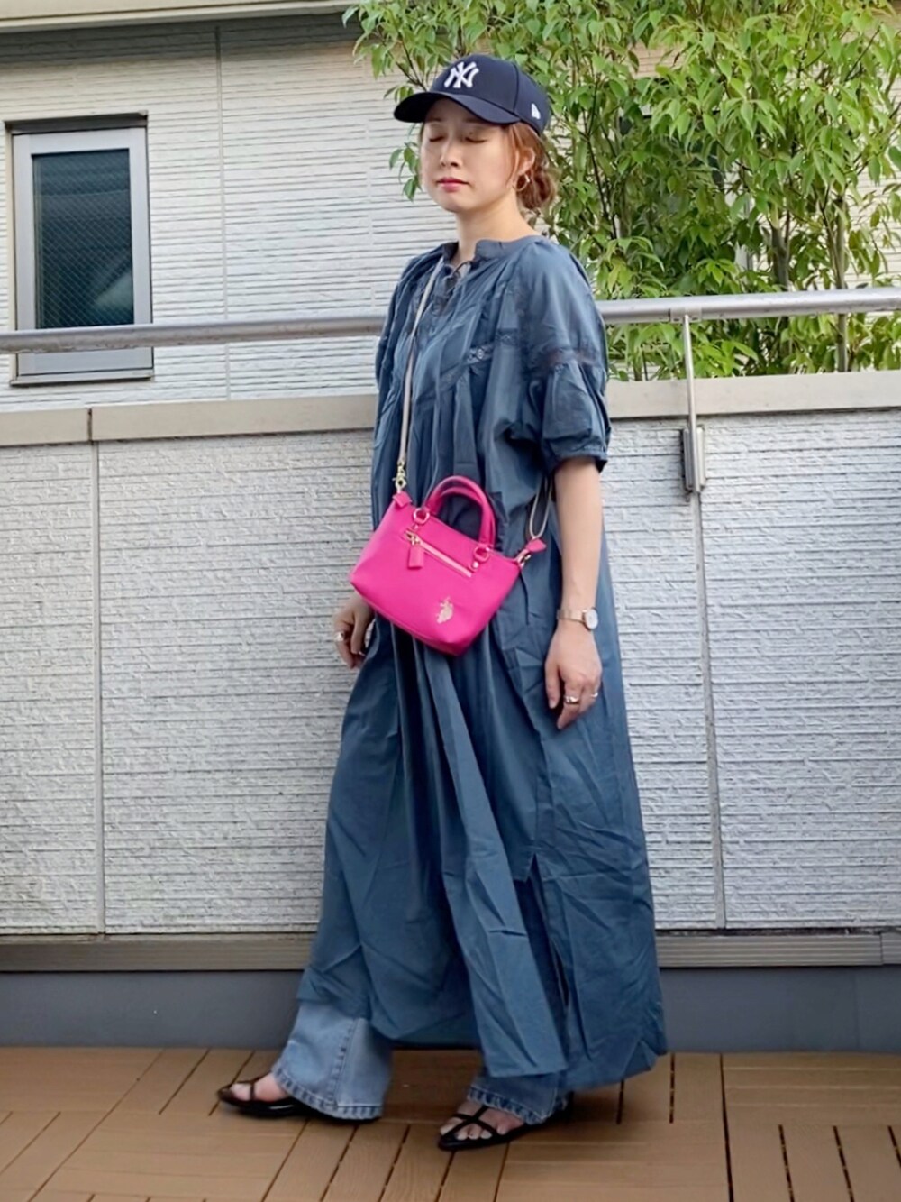 ブルー系のワンピース、ブルー系のデニムパンツ、ピンク系のショルダーバッグを着用したレディースの夏コーディネートの2枚目の写真