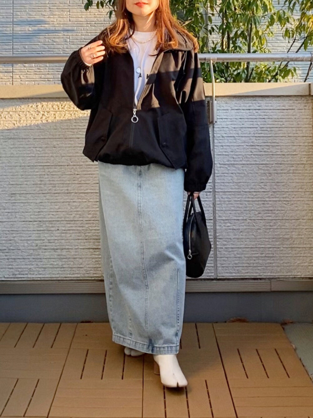 ホワイト系のTシャツ/カットソー、ブラック系のその他アウター、ブルー系のデニムスカートを着用したレディースの春コーディネートの5枚目の写真
