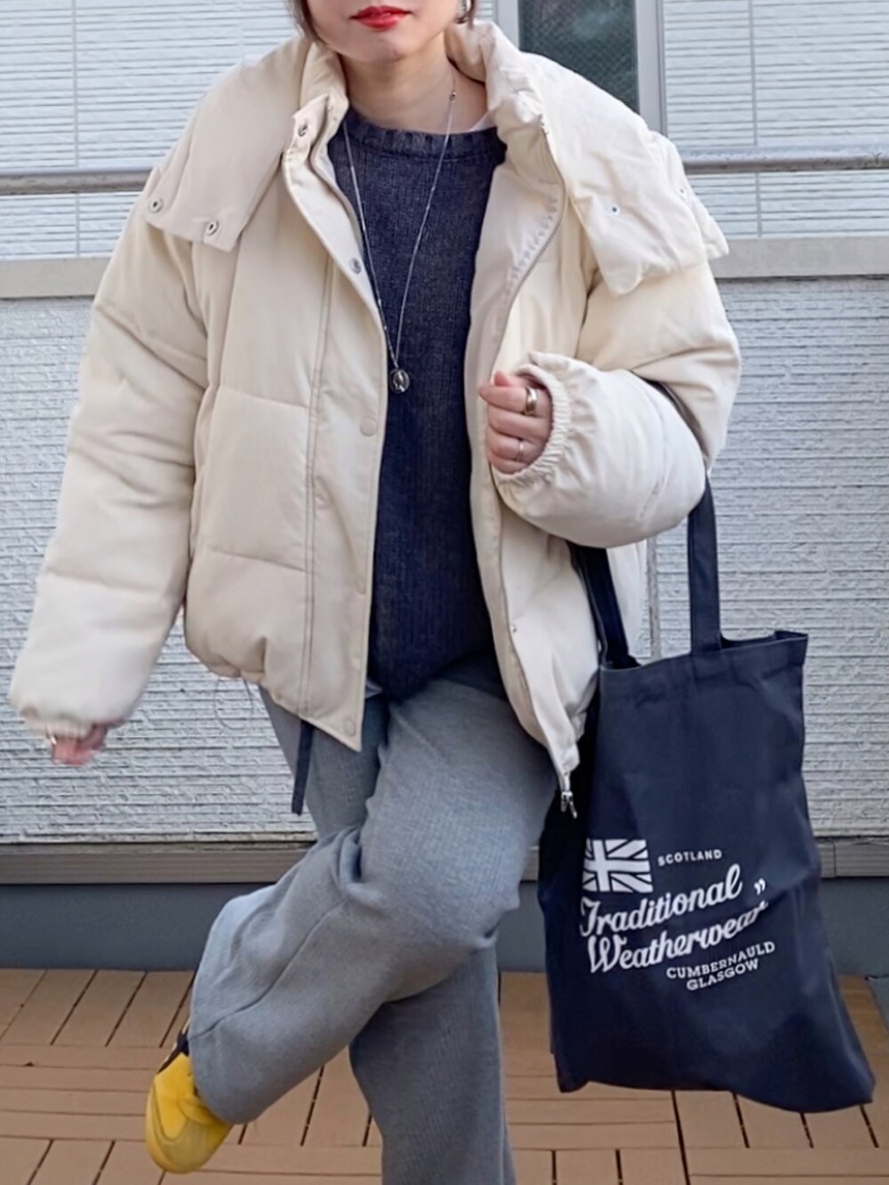 ホワイト系のダウンジャケット/コート、グレー系のニット/セーター、グレー系のその他パンツを着用したレディースの冬コーディネートの4枚目の写真