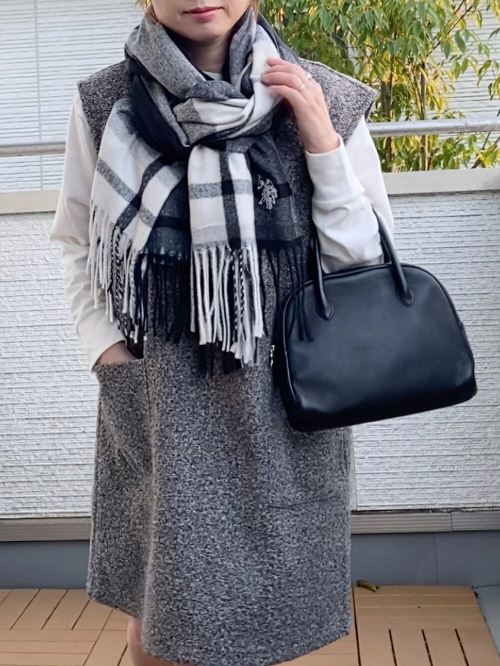 グレー系のジャンパースカート、グレー系のスニーカー、ブラック系のショルダーバッグを着用したレディースの秋コーディネートの5枚目の写真