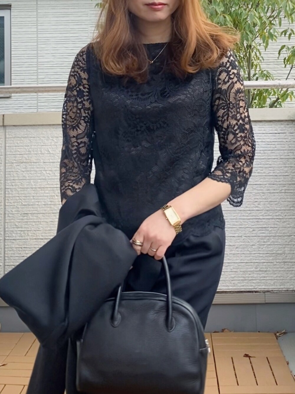 ブラック系のスーツセット、ブラック系のショルダーバッグ、ブラック系のブーツを着用したレディースの冬コーディネートの5枚目の写真