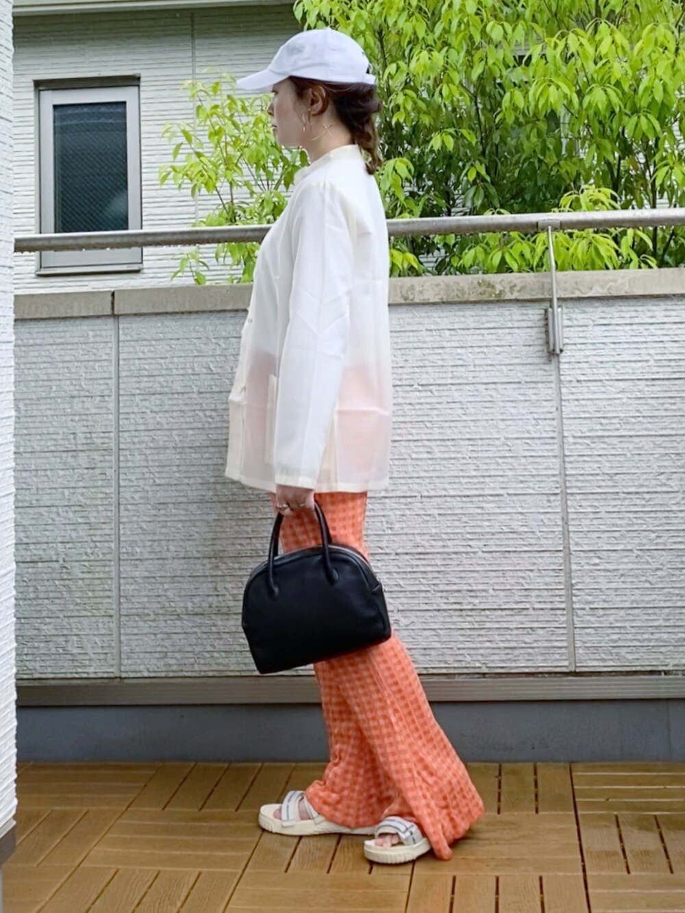 ホワイト系のシャツ/ブラウス、オレンジ系のその他パンツ、ブラック系のショルダーバッグを着用したレディースの春コーディネートの4枚目の写真