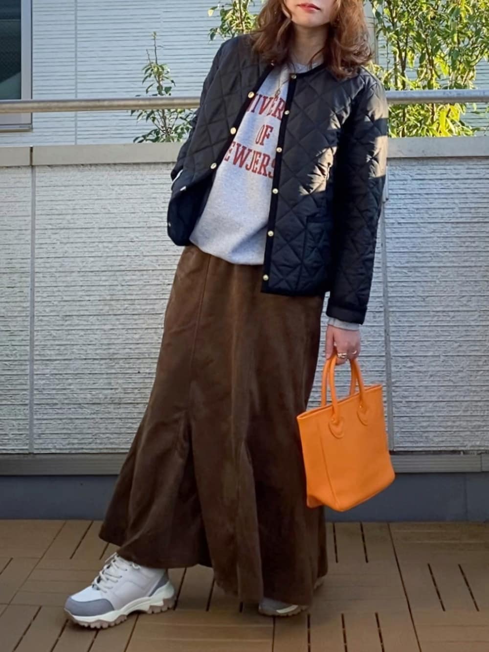 グレー系のスウェット、ブラック系のノーカラージャケット、ブラウン系のスカートを着用したレディースの秋コーディネートの3枚目の写真