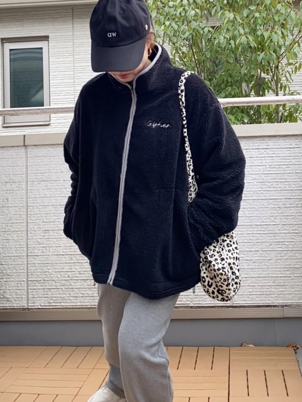 ブラック系のブルゾン、グレー系のその他パンツ、ホワイト系のトートバッグを着用したレディースの冬コーディネートの4枚目の写真