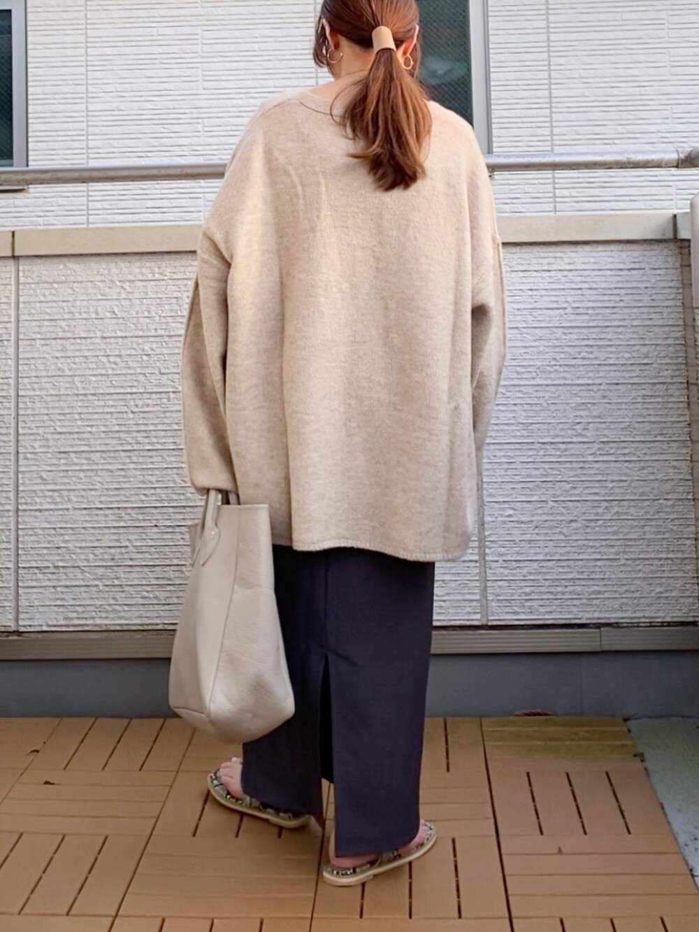 ベージュ系のカーディガン/ボレロ、グレー系のスカート、ベージュ系のトートバッグを着用したレディースの秋コーディネートの2枚目の写真
