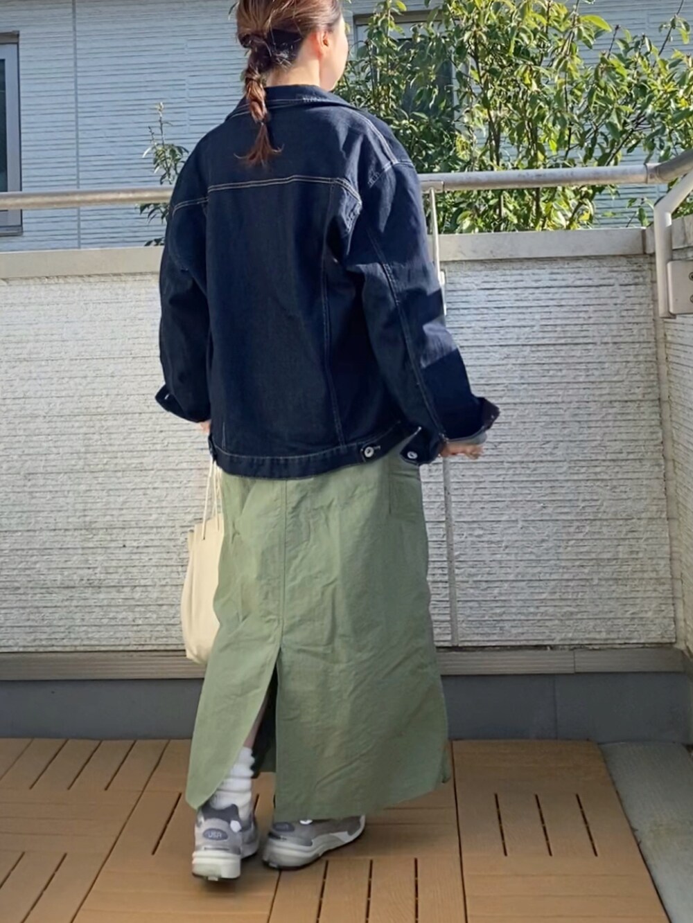 グリーン系のワンピース、ホワイト系のTシャツ/カットソー、ブルー系のデニムジャケットを着用したレディースの春コーディネートの3枚目の写真