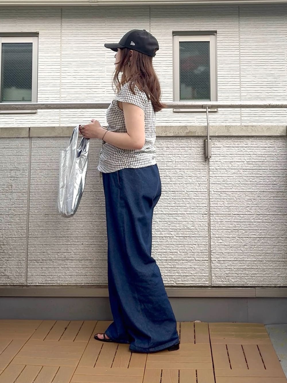 ホワイト系のシャツ/ブラウス、ブルー系のデニムパンツ、ブラック系のキャップを着用したレディースの夏コーディネートの3枚目の写真