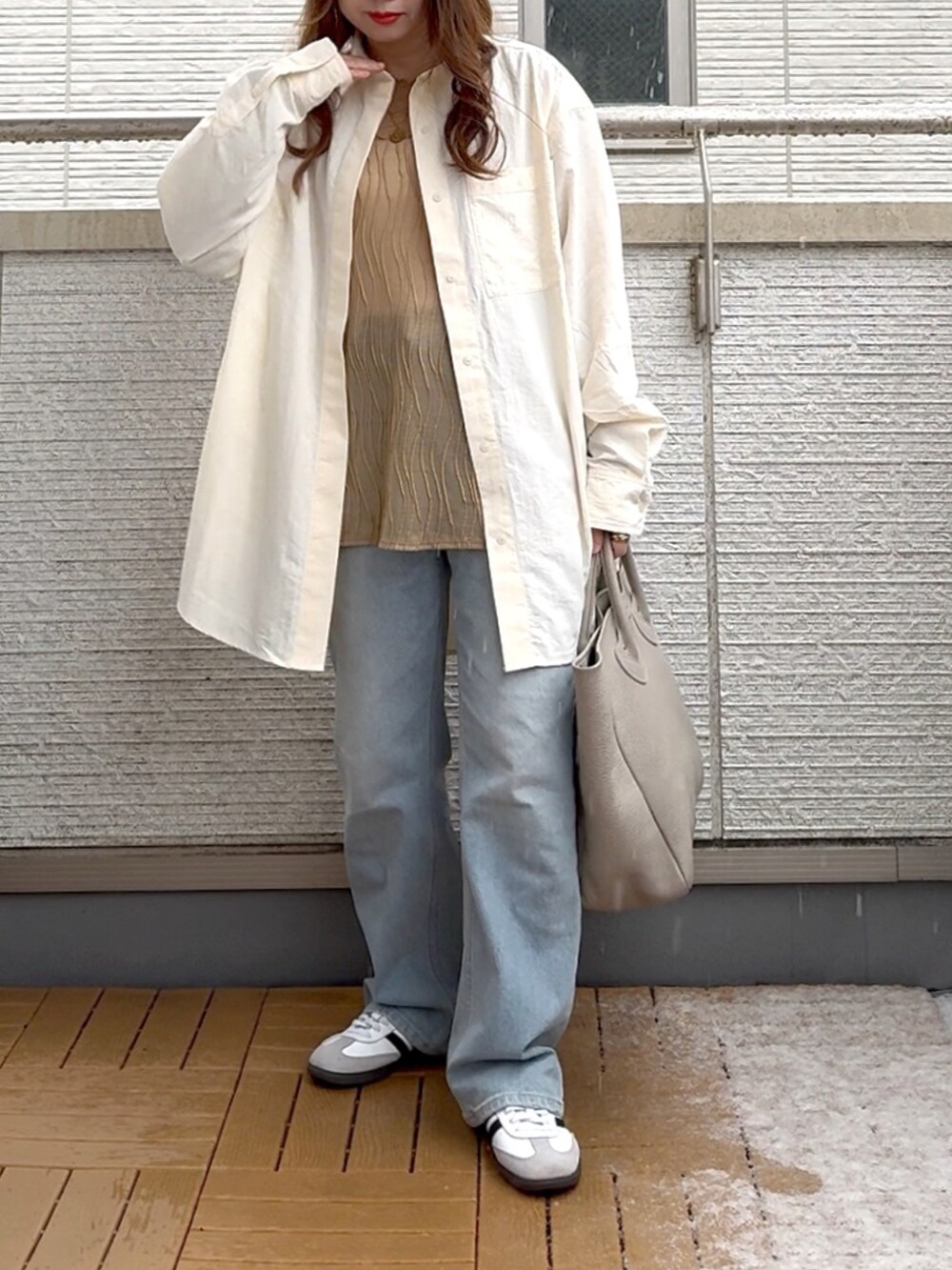 ホワイト系のシャツ/ブラウス、ベージュ系のTシャツ/カットソー、ブルー系のデニムパンツを着用したレディースの春コーディネートの2枚目の写真