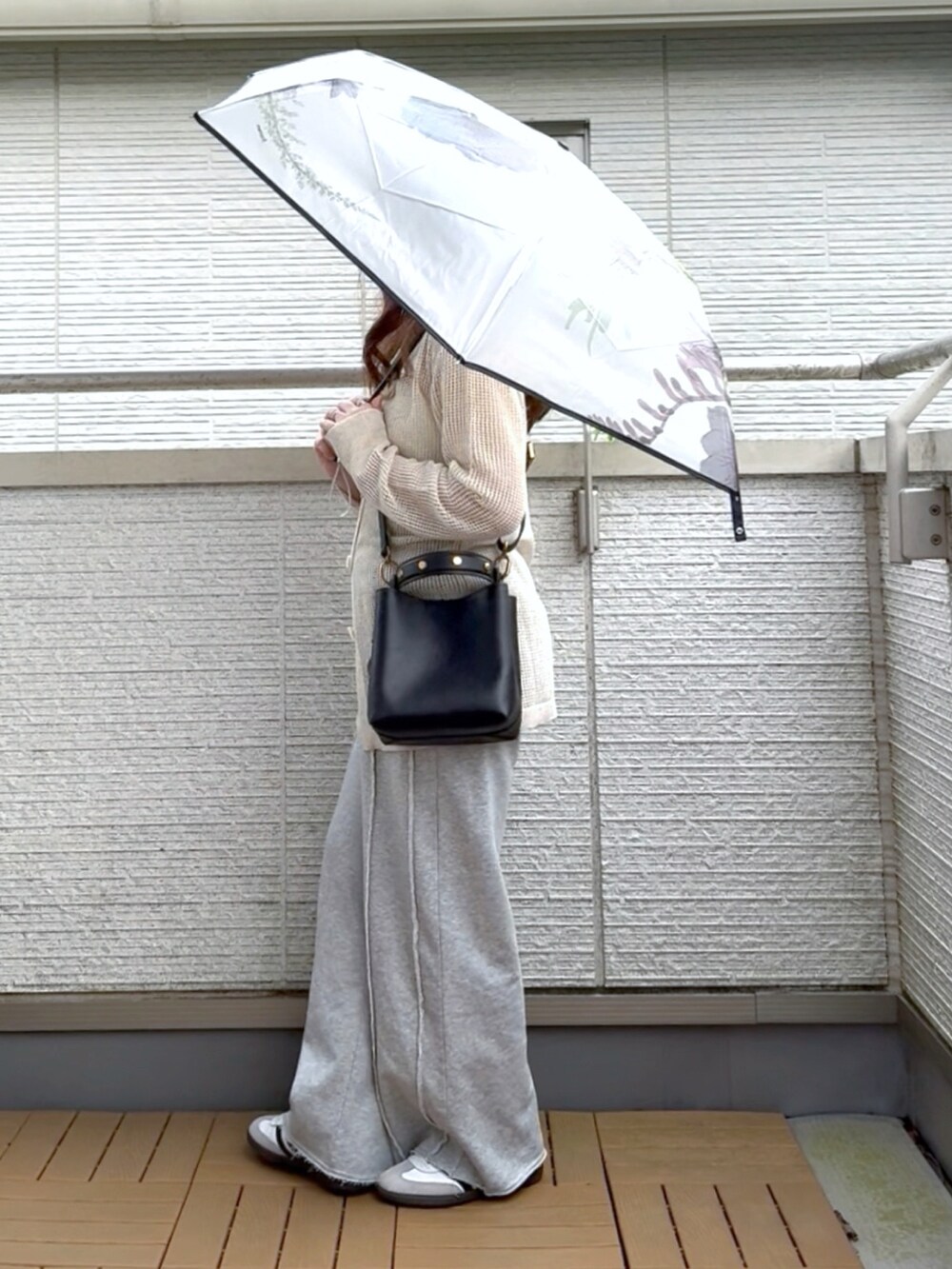 ベージュ系のカーディガン/ボレロ、ブラック系のショルダーバッグ、グレー系のスウェットパンツを着用したレディースの春コーディネートの2枚目の写真