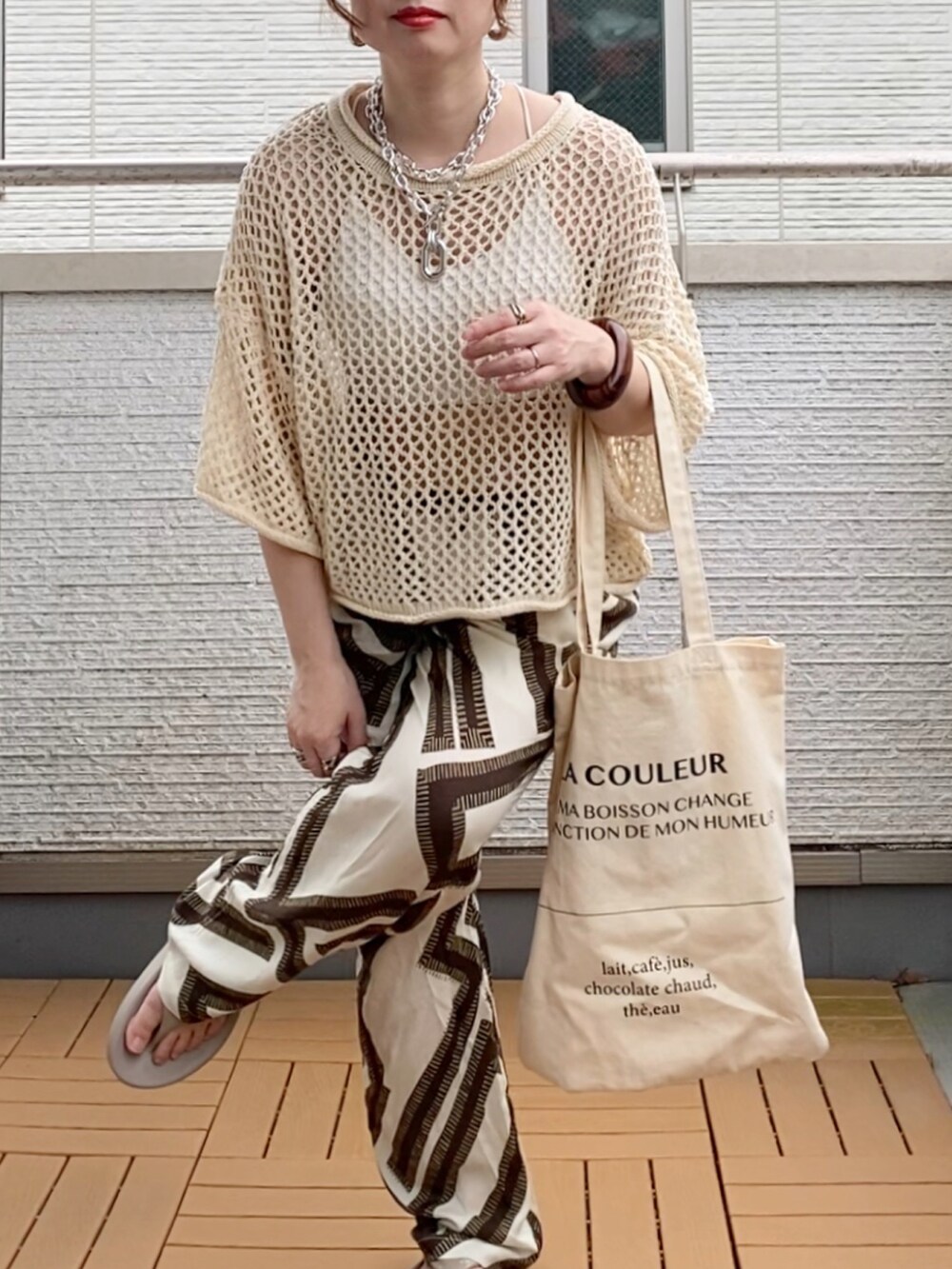 ホワイト系のニット/セーター、ホワイト系のその他パンツ、ホワイト系のトートバッグを着用したレディースの夏コーディネートの4枚目の写真