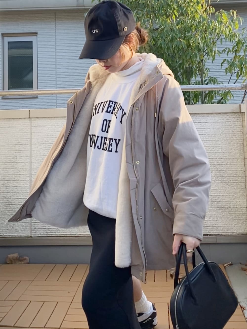 ベージュ系のマウンテンパーカー、ホワイト系のスウェット、ブラック系のスカートを着用したレディースの冬コーディネートの4枚目の写真