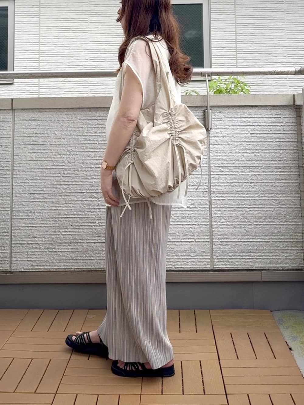 ホワイト系のTシャツ/カットソー、グレー系のスカート、ベージュ系のショルダーバッグを着用したレディースの春コーディネートの3枚目の写真