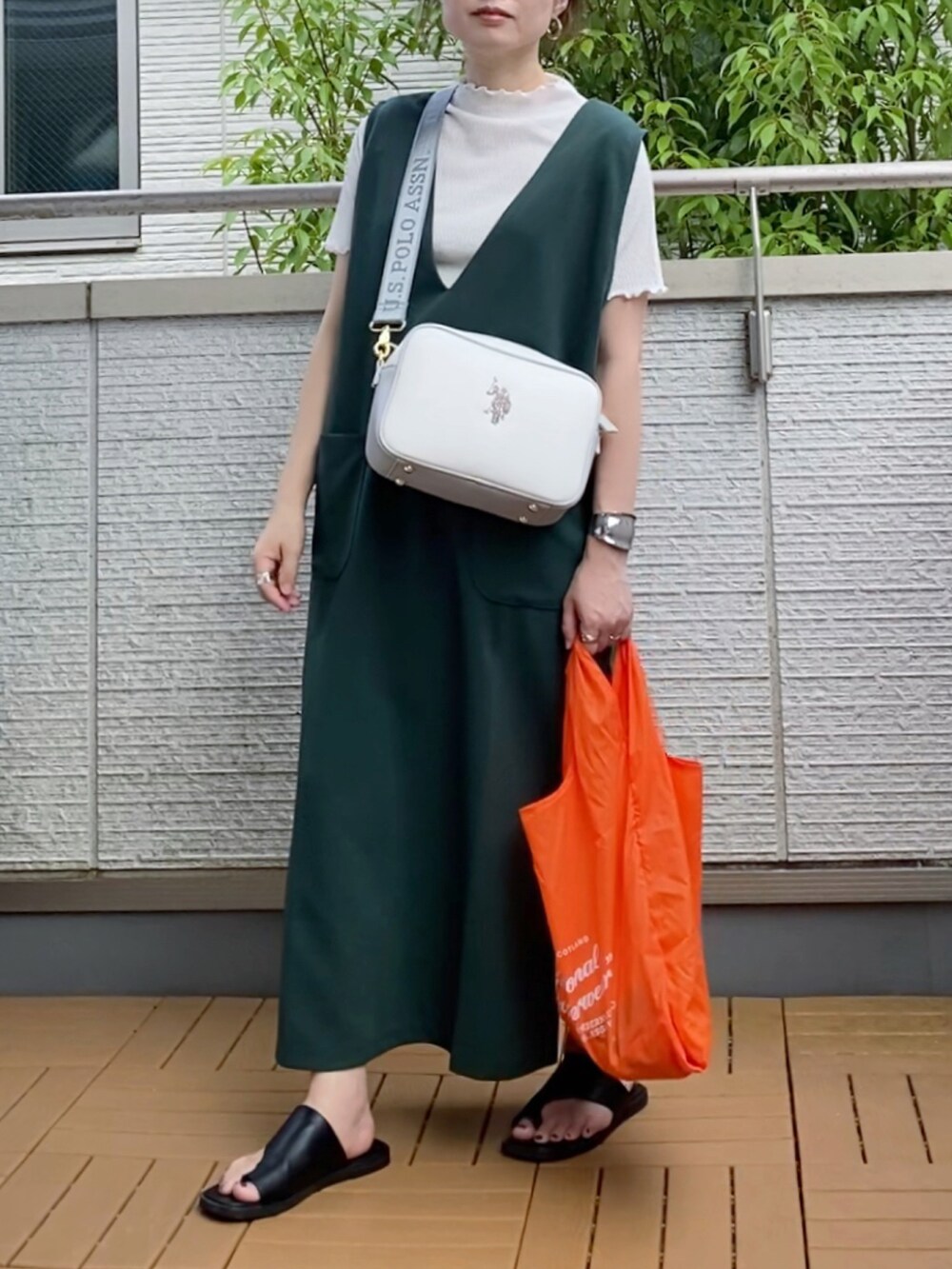 グリーン系のワンピース、ホワイト系のショルダーバッグ、オレンジ系のエコバッグ/サブバッグを着用したレディースの夏コーディネートの2枚目の写真