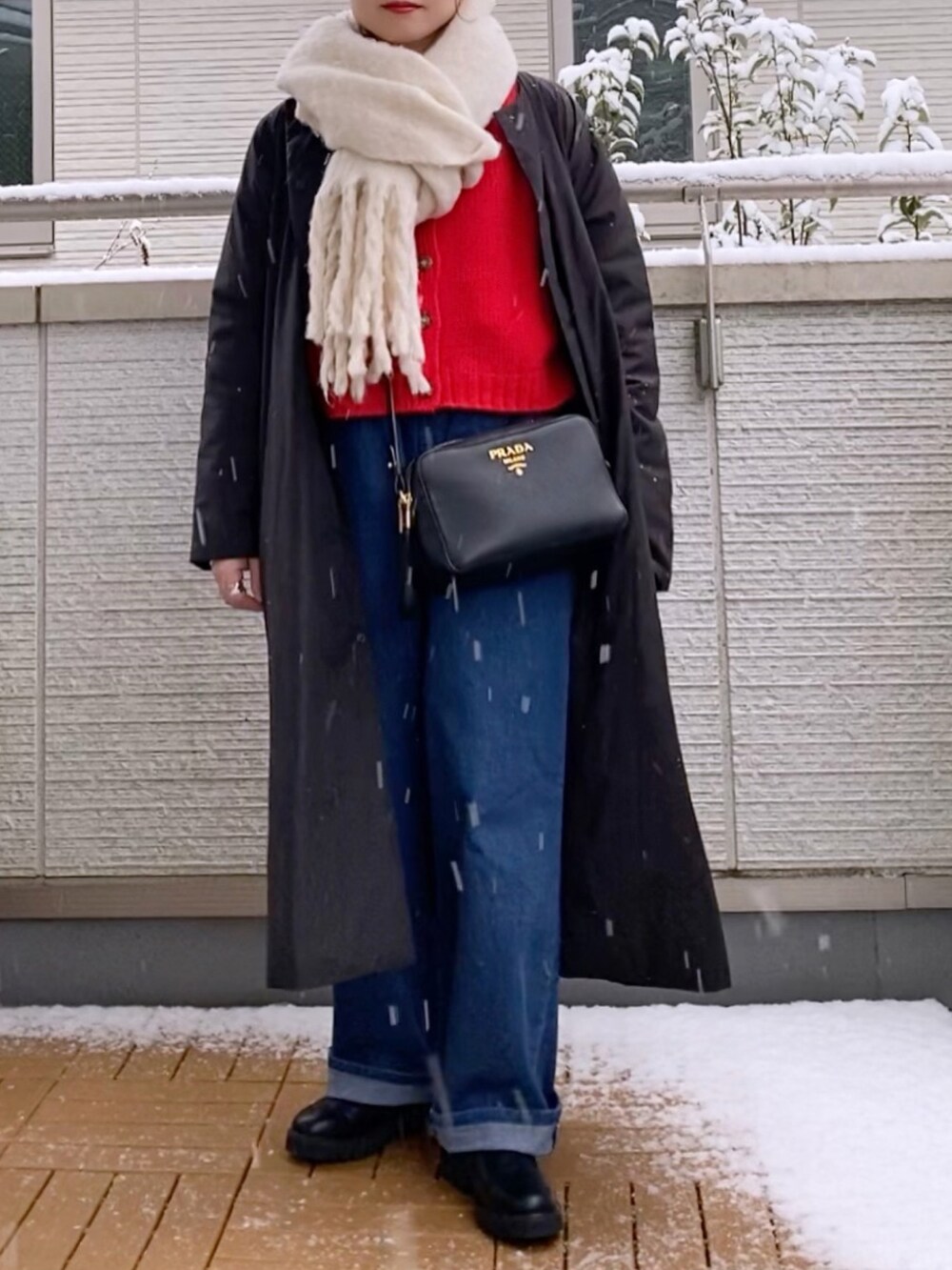 レッド系のカーディガン/ボレロ、ブルー系のその他パンツ、ブラック系のブーツを着用したレディースの冬コーディネートの2枚目の写真