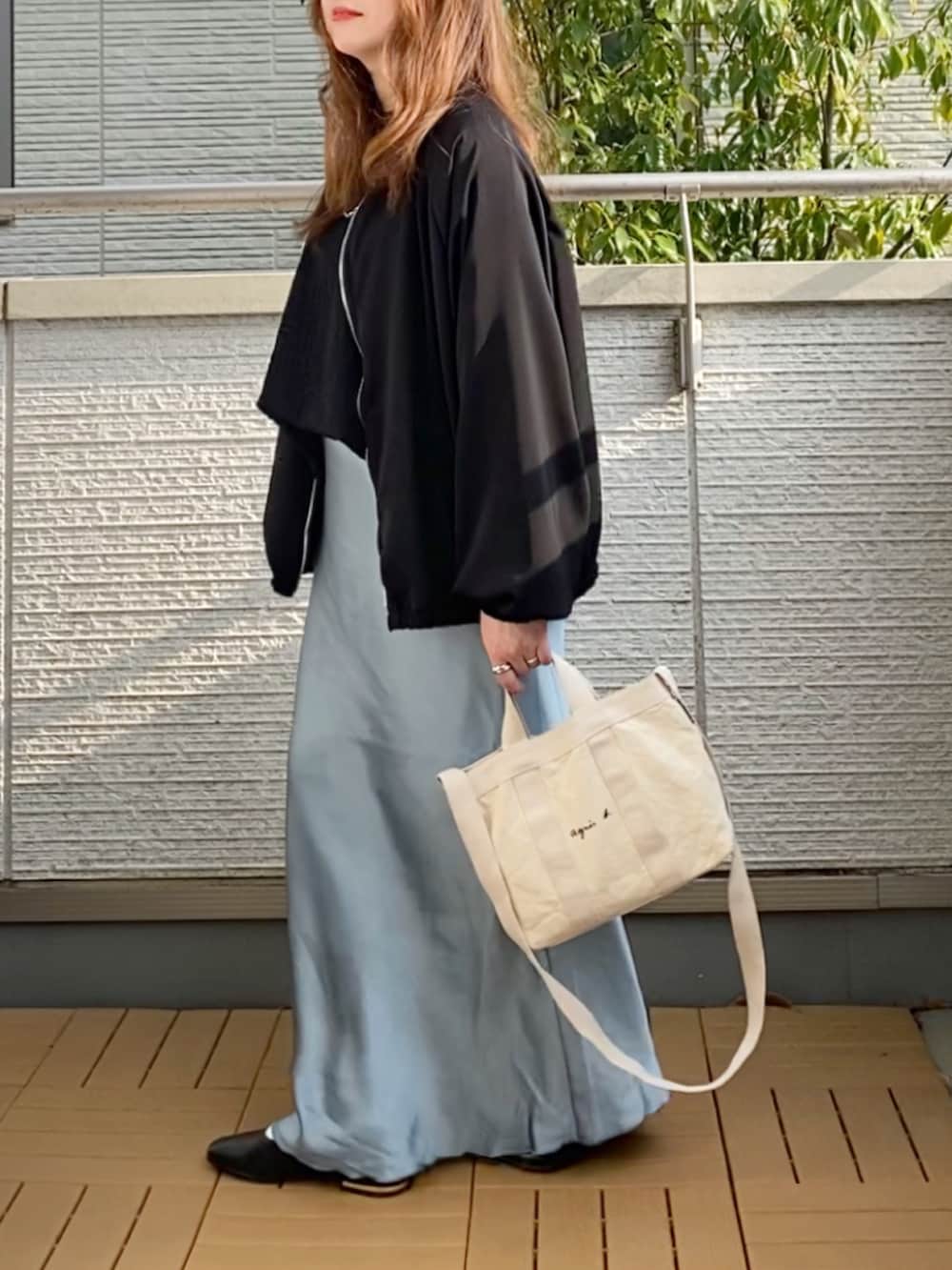 ブラック系のブルゾン、ブラック系のTシャツ/カットソー、ブルー系のスカートを着用したレディースの春コーディネートの3枚目の写真