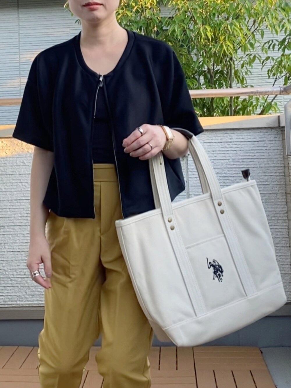 ブラック系のカーディガン/ボレロ、イエロー系のその他パンツ、ホワイト系のトートバッグを着用したレディースの秋コーディネートの2枚目の写真