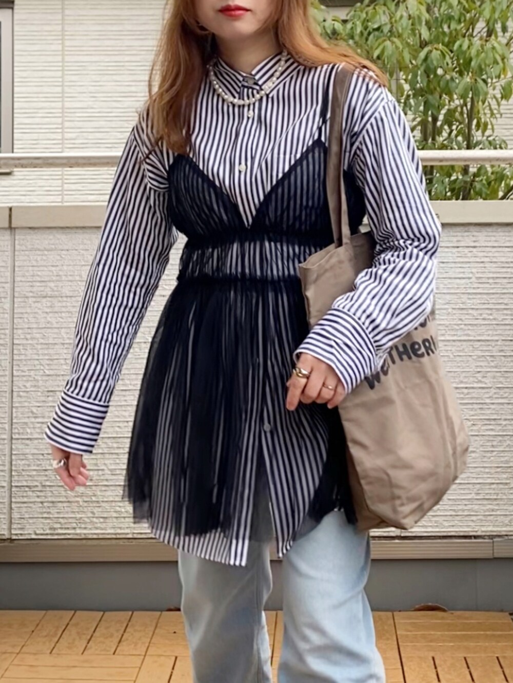 ブラック系のキャミソール、その他のシャツ/ブラウス、ブルー系のデニムパンツを着用したレディースの春コーディネートの2枚目の写真