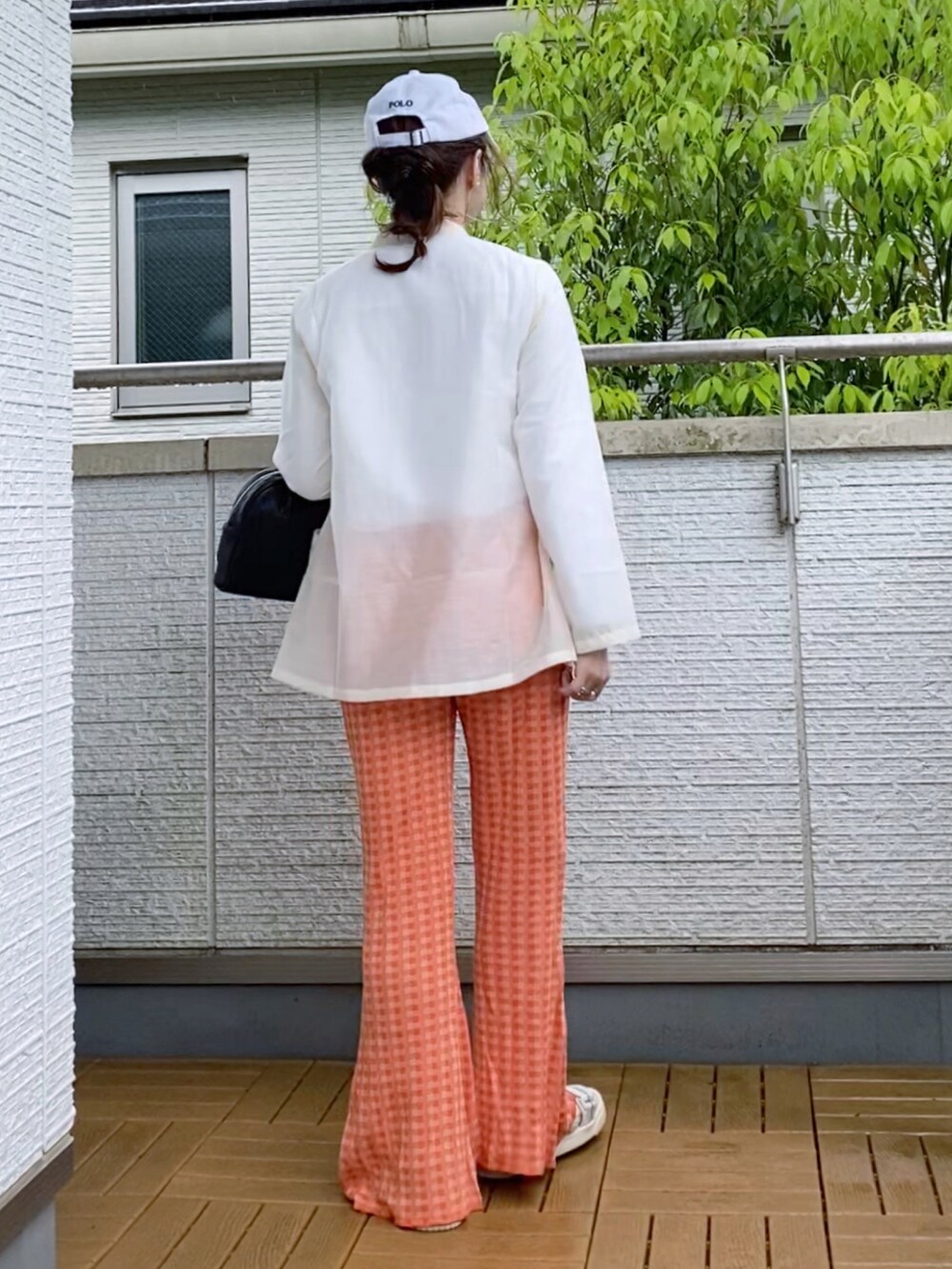 ホワイト系のシャツ/ブラウス、オレンジ系のその他パンツ、ブラック系のショルダーバッグを着用したレディースの春コーディネートの3枚目の写真