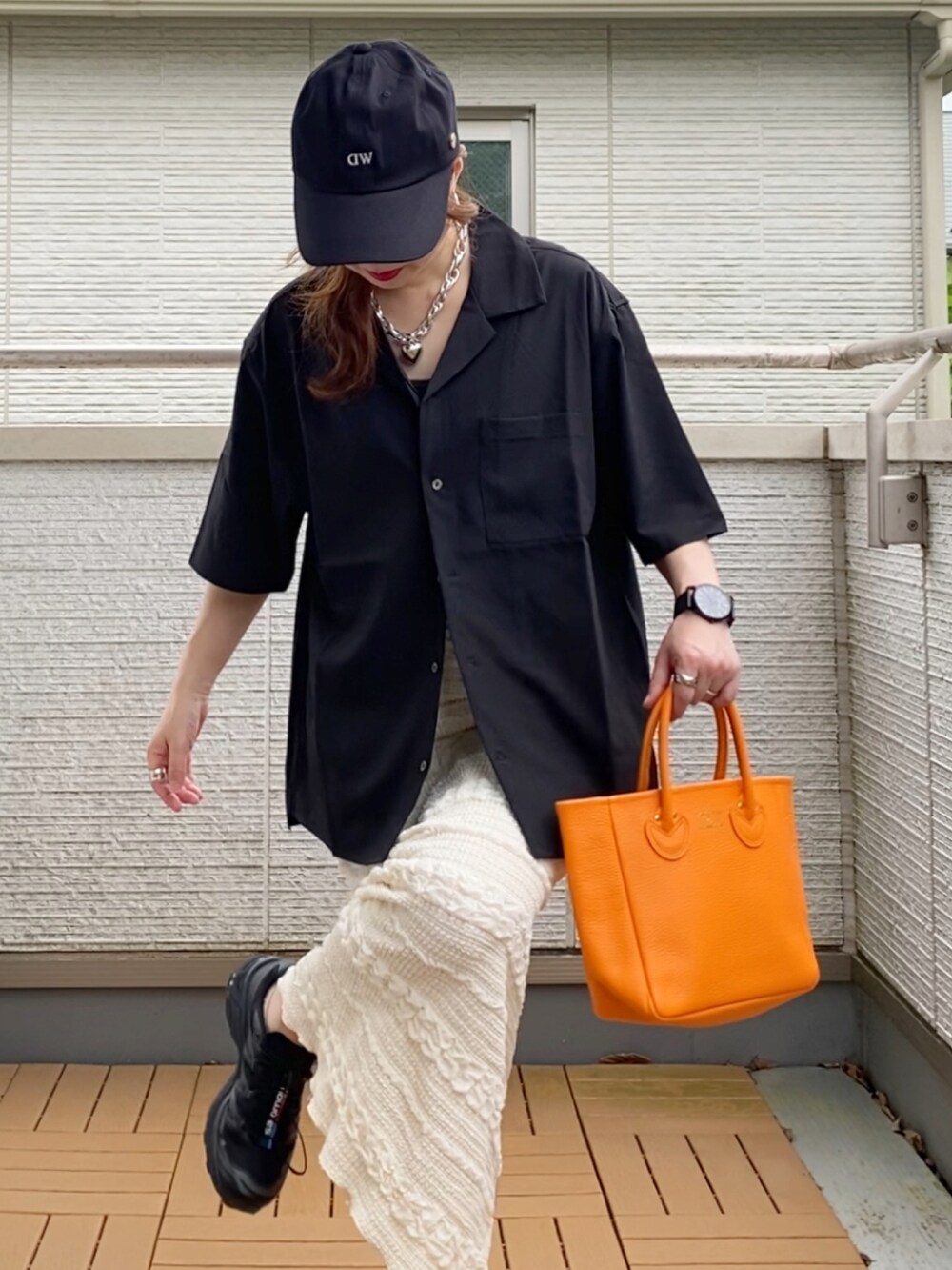 ブラック系のシャツ/ブラウス、ホワイト系のスカート、オレンジ系のトートバッグを着用したレディースの夏コーディネートの4枚目の写真
