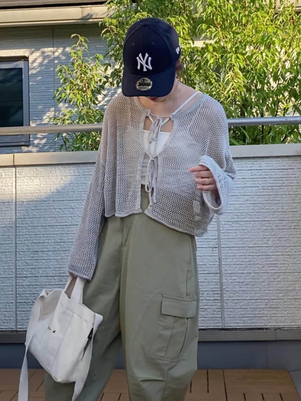 グレー系のカーディガン/ボレロ、ホワイト系のキャミソール、ベージュ系のカーゴパンツを着用したレディースの夏コーディネートの4枚目の写真