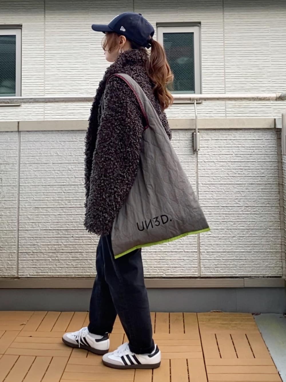 グレー系のブルゾン、ホワイト系のTシャツ/カットソー、グレー系のトートバッグを着用したレディースの秋コーディネートの3枚目の写真